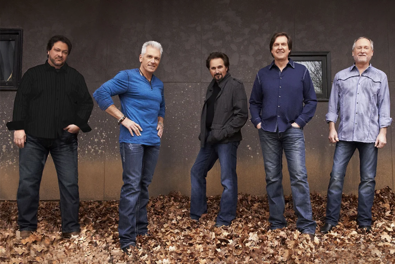 Country music band Diamond Rio standing along a building wall for band image. 