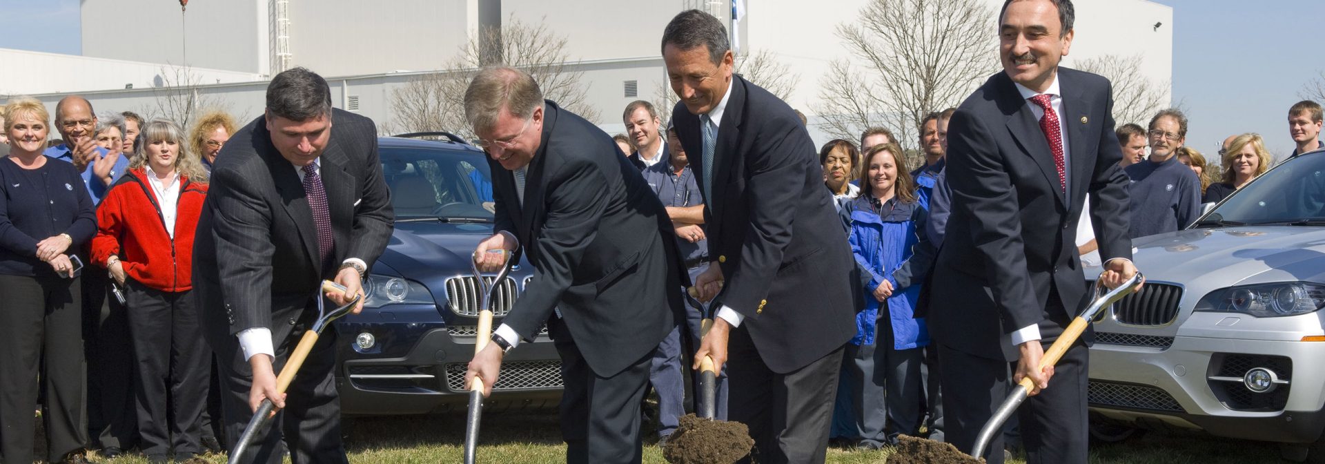 Groundbreaking for new assembly plant at press conference announcing additional invest and paint shop expansion. Associates gather around an X model as they watch with excitement.