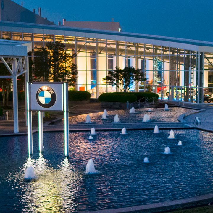 Zentrum Museum lit up at night with X display and fountain out front. 