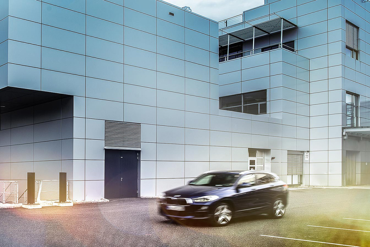 Ein Fahrzeug fährt vor dem BMW Group Werk Steyr