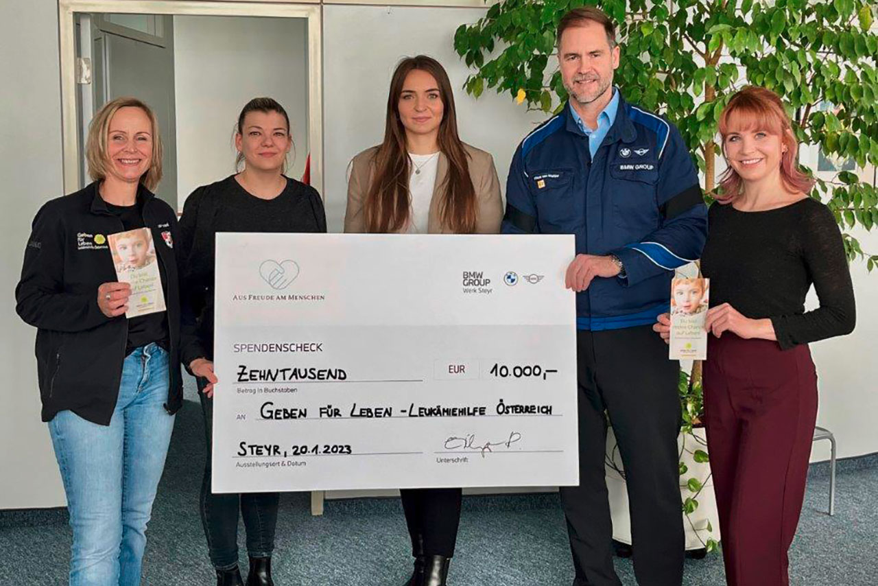 Mitarbeiter des BMW Group Werk Steyr zeigen einen "Scheck" mit der Spendensumme