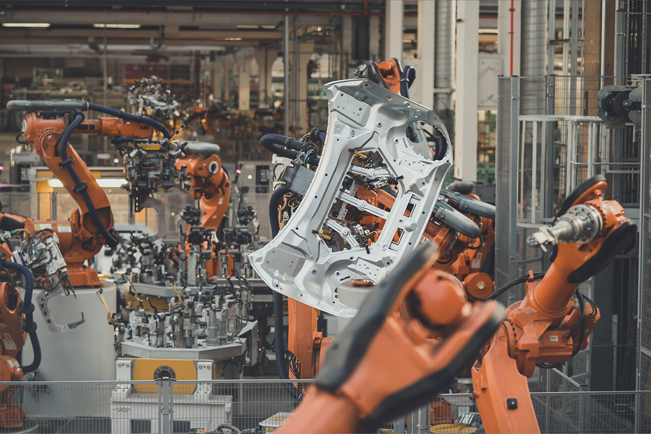 Robotic arms working on car parts. 