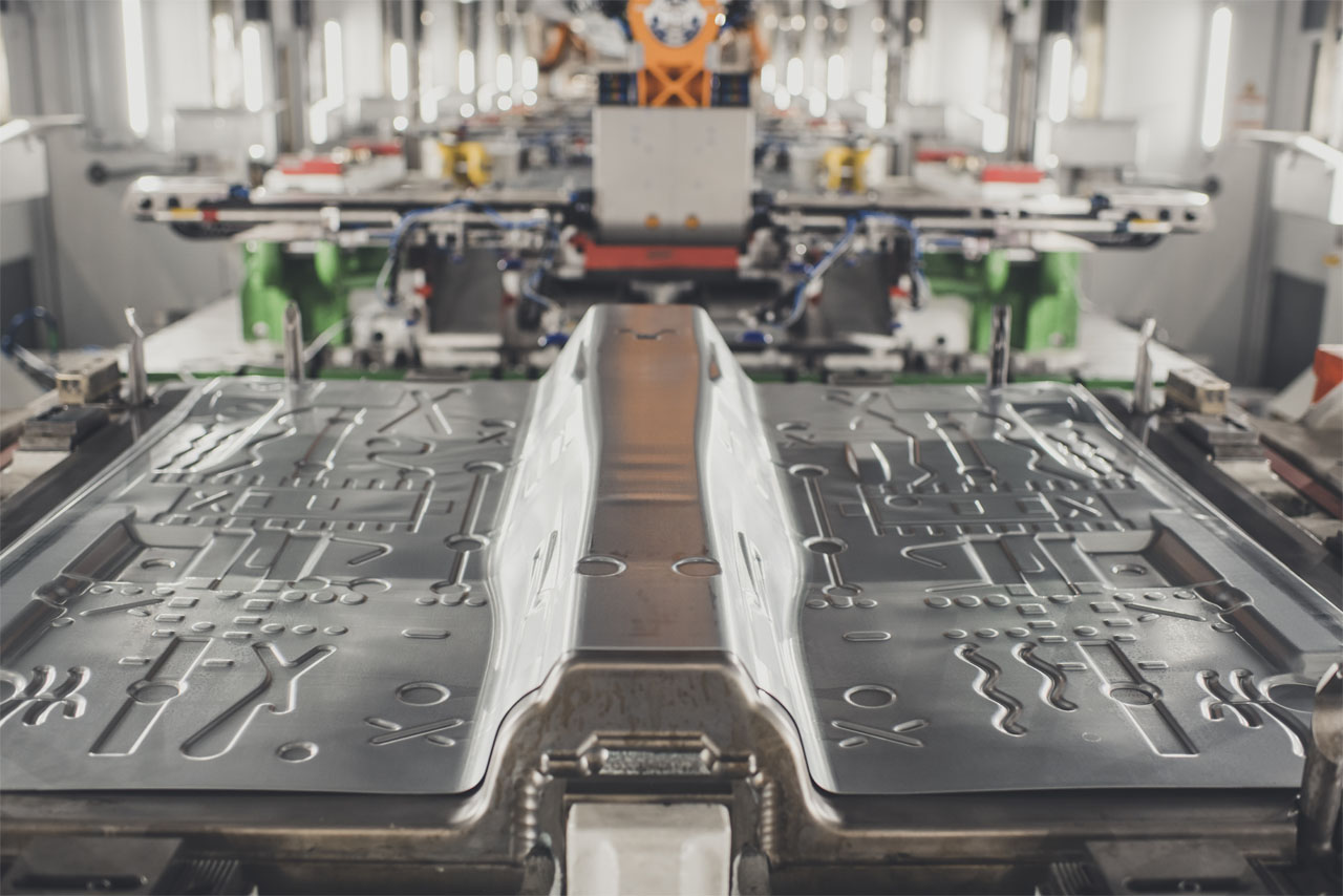 A factory environment with workers actively manufacturing metal parts on the production line.