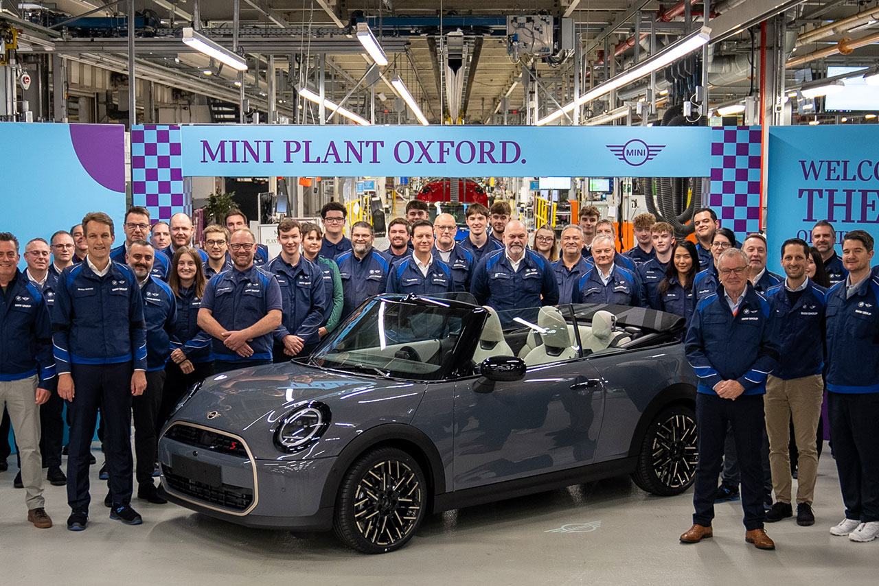A huge team of BMW employees posing togther with the first ever MINI Cooper convertible off the Oxford plant. 