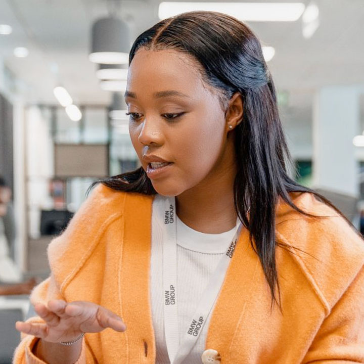 A recent graduate is explaining something to her colleague. 