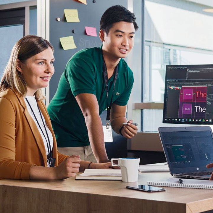Two Students and a BMW employee are having a collaborative conversation in a modern office setting.