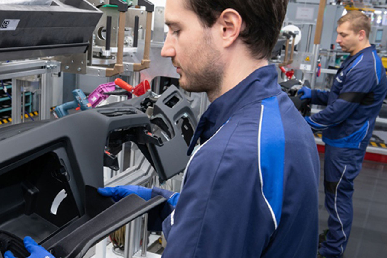 Ein Mitarbeiter arbeitet an Interieurteilen eines BMW Fahrzeugs.