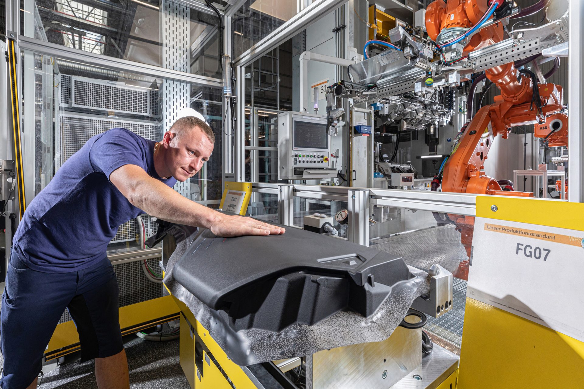 Ein Mann in der Produktion arbeitet an dem Cockpit eines neuen 1er BMWs.