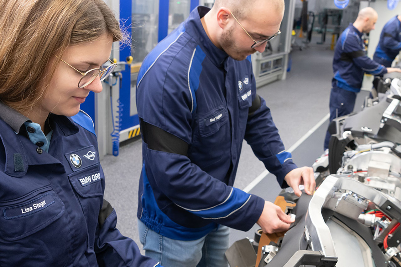 Two employees working on a machine at BMW Plant Wackersdorf, to optimize production and increase efficiency.