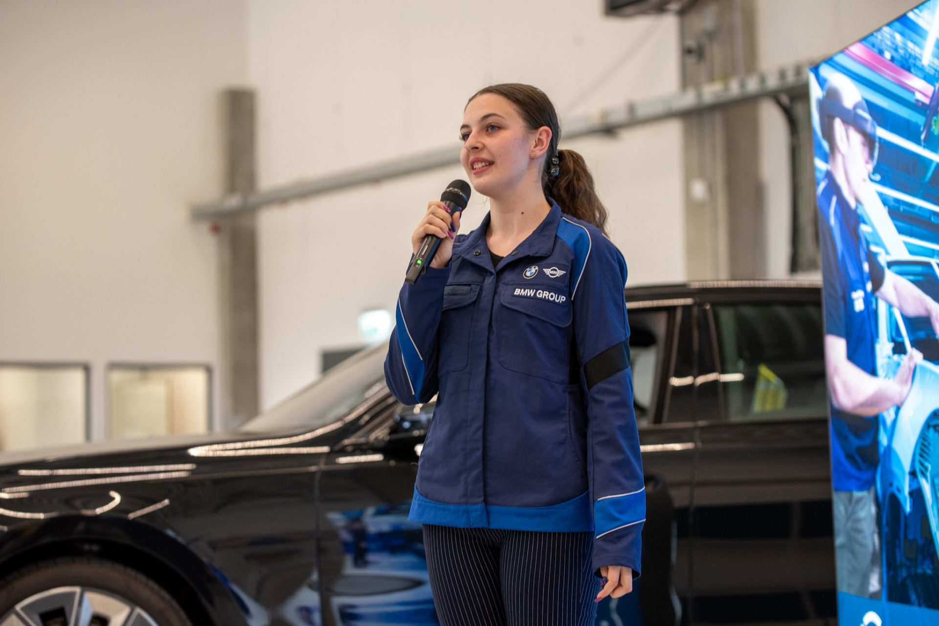 A young woman is talking in front of a car