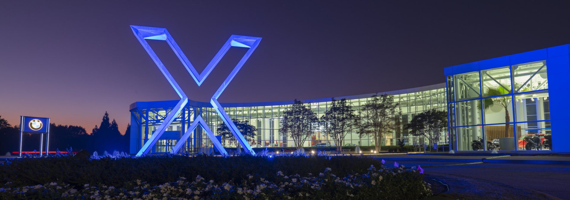 Nighttime shot of BMW Zentrum Museum with X branding logo light up. 
